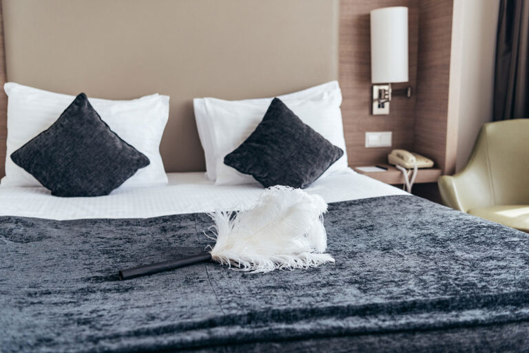 Hotel Pillows and feather duster in a hotel bed.