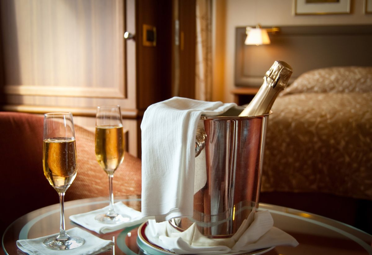 A hotel room with a bucket of wine.