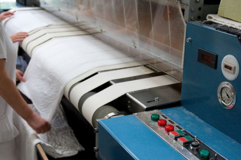 A person working on a laundry pressing machine.