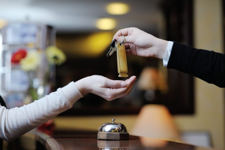 Receptionist handing key to guest.