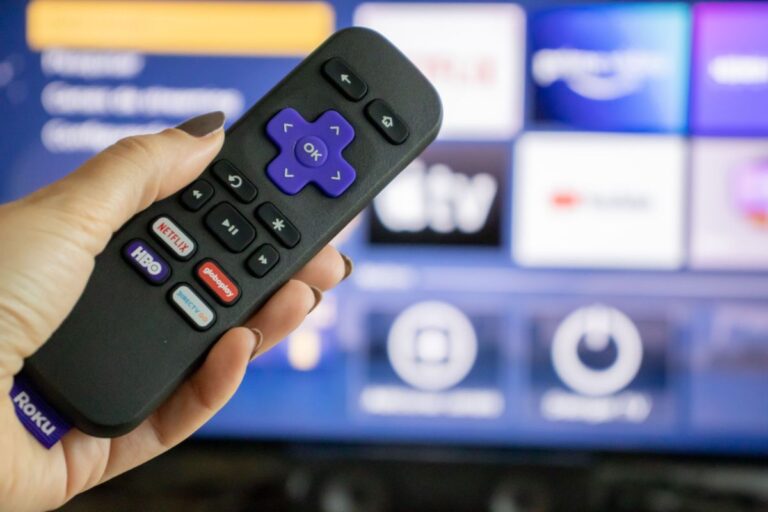 Roku remote control and a smart TV.