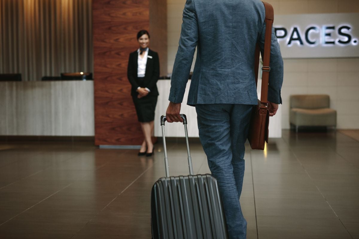 A man entering a hotel and a staff waiting.