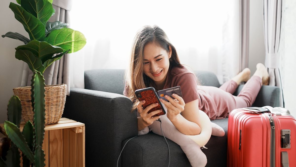 A woman holding her phone and credit card.