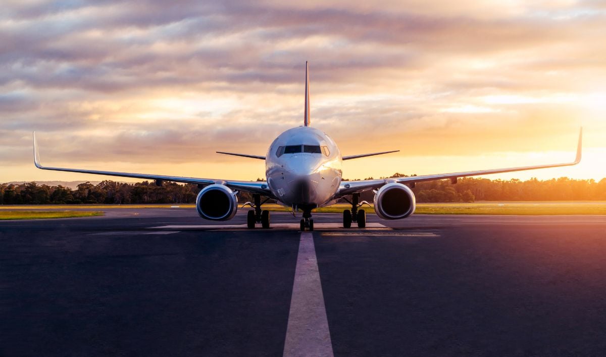 A plane on an runway during sunset.