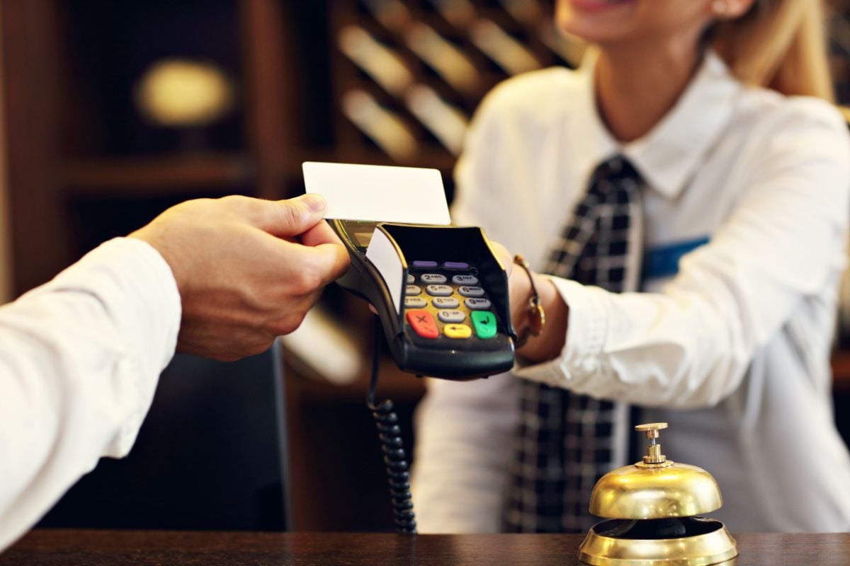 A person paying using a debit card at the front desk.