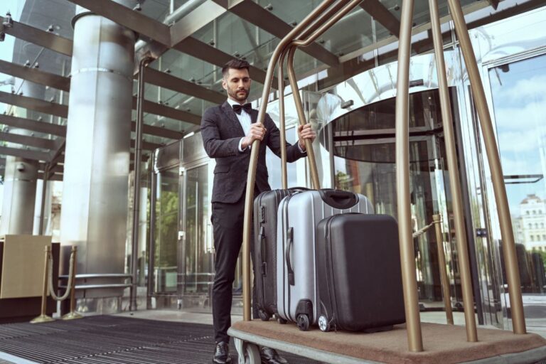 A hotel worker holding customers luggage.