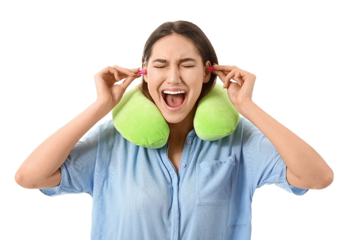 A woman with her earplug and neck pillow.