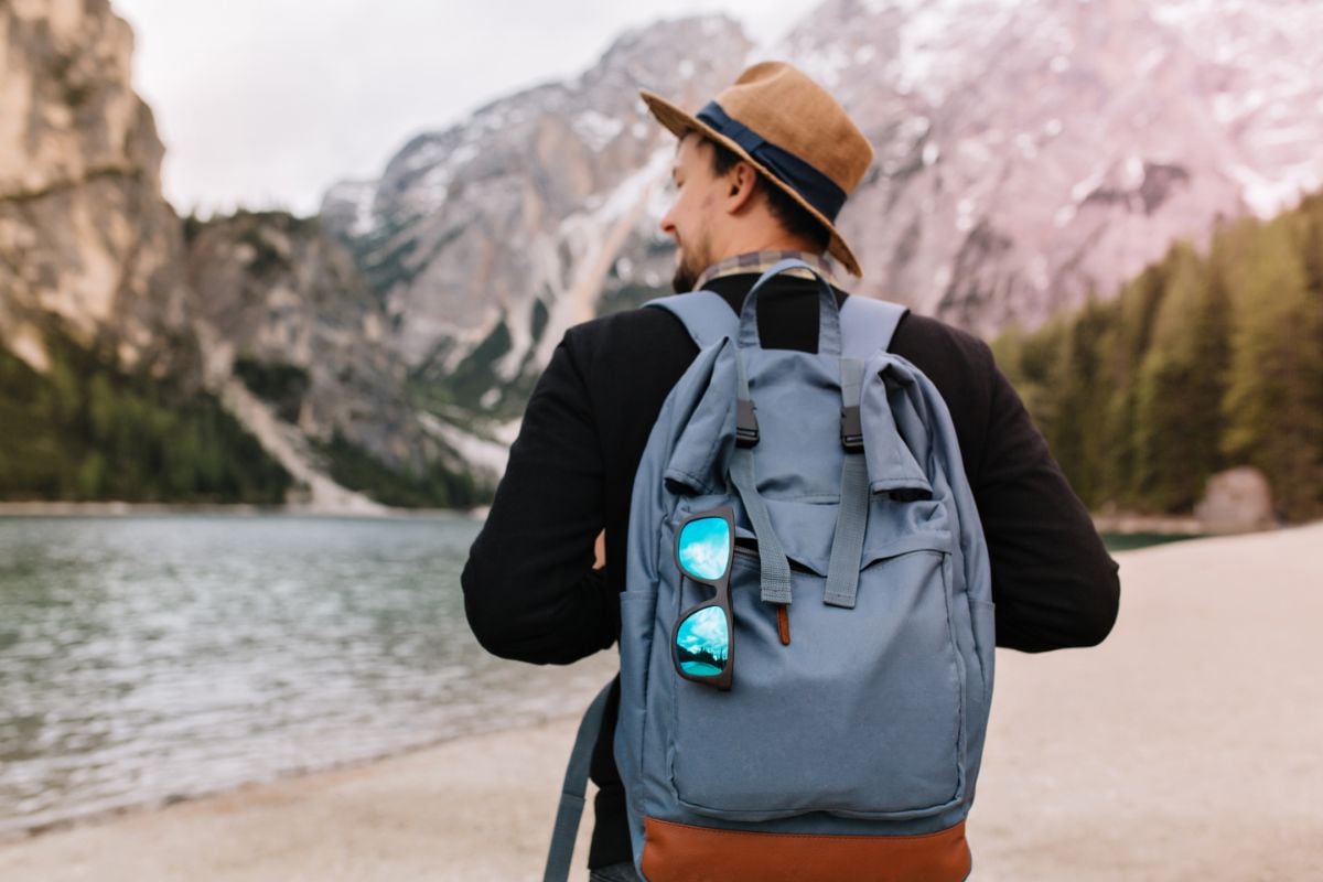 A man on the beach with his back pack.