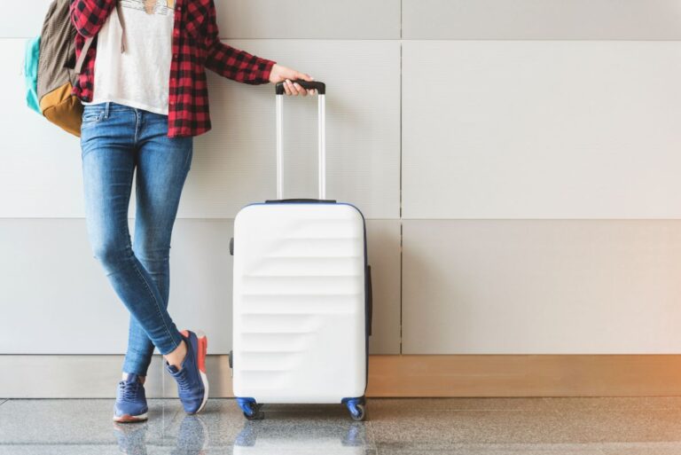 A woman holding a travel luggage.