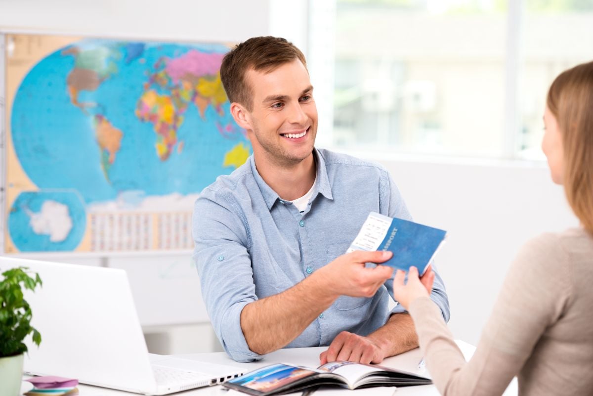 A man handing a passport to a lady.