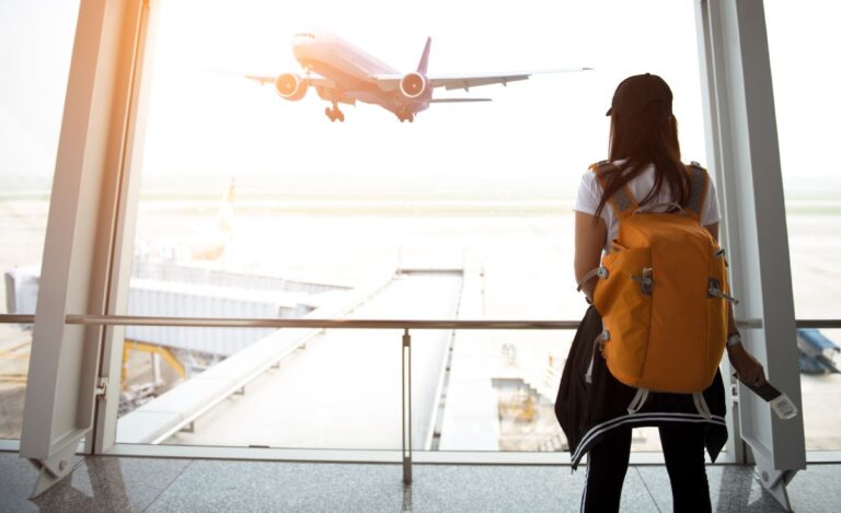 A woman looking on the airport window.