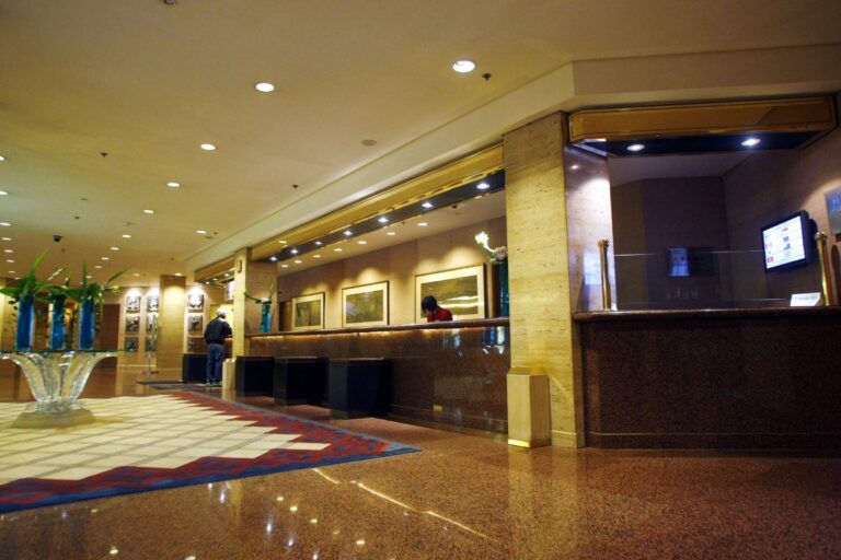 A hotel lobby with carpet and front desk.