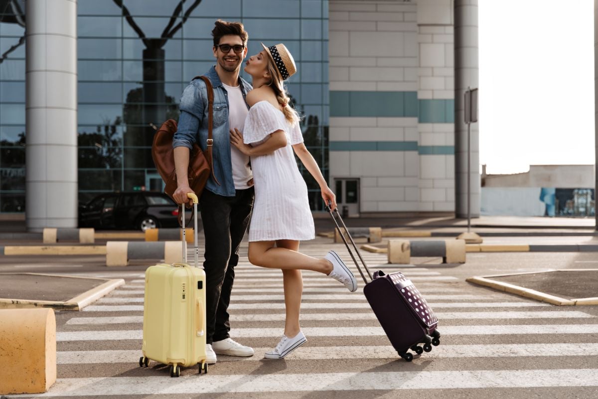 Beautiful couple holding their luggage.