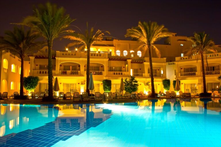 Luxurious hotel with swimming pool and palm trees.