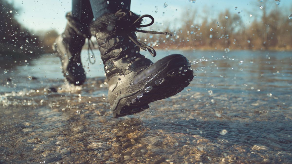 A person wearing waterproof boots on the river.