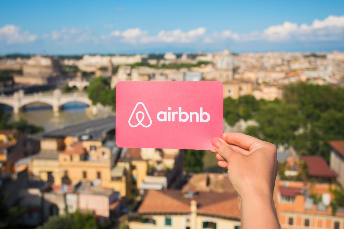 A person holding an airbnb logo.