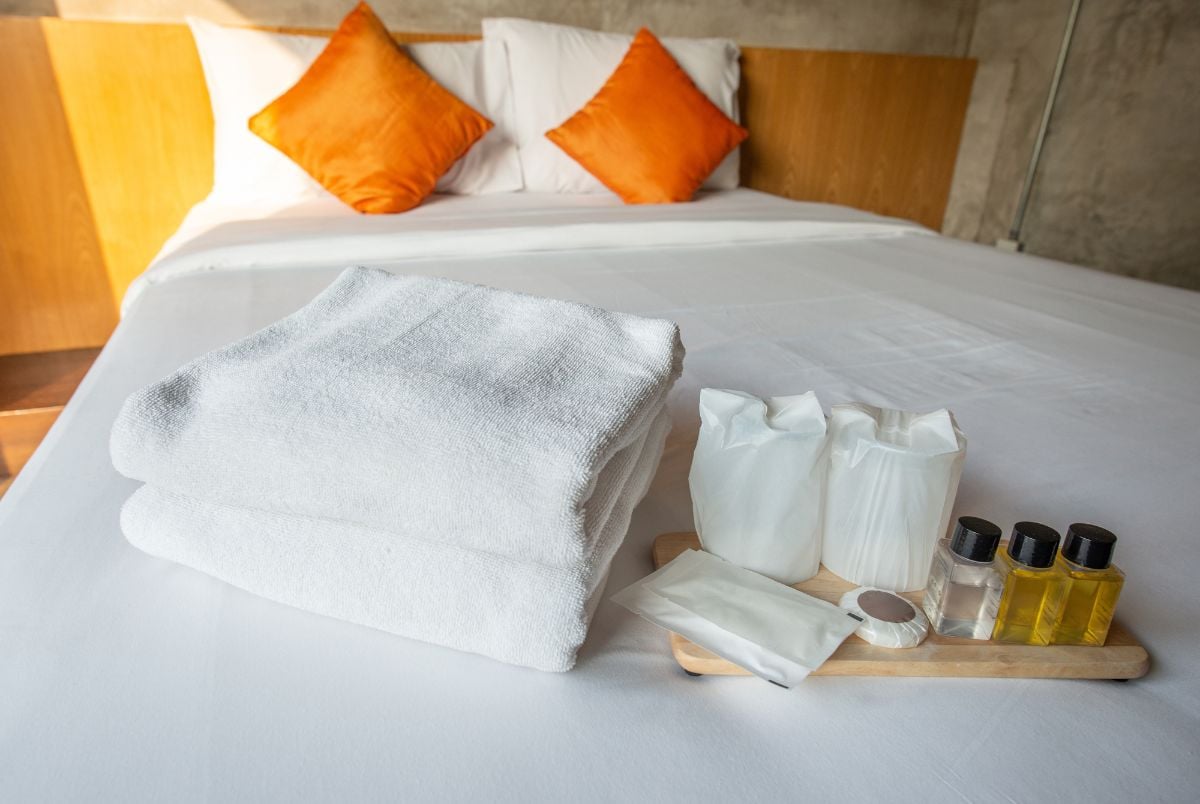 Hotel bed with towels and pillows.