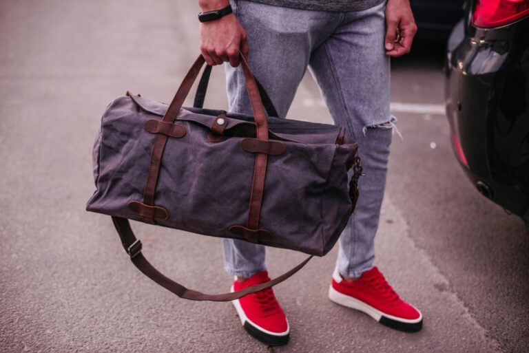 A man carrying a bag with leather strap.