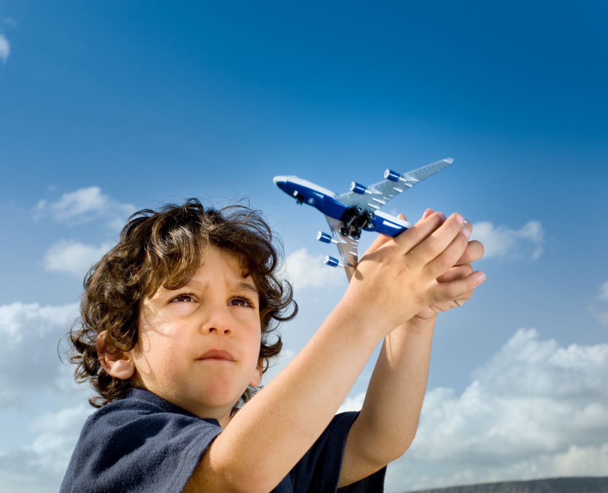 A child playing on a toy airplane.