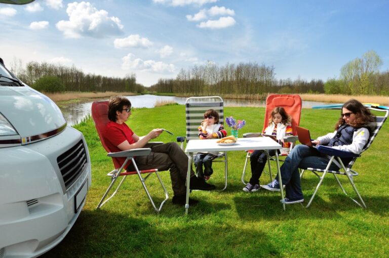 A family enjoying a picnic with their RV.