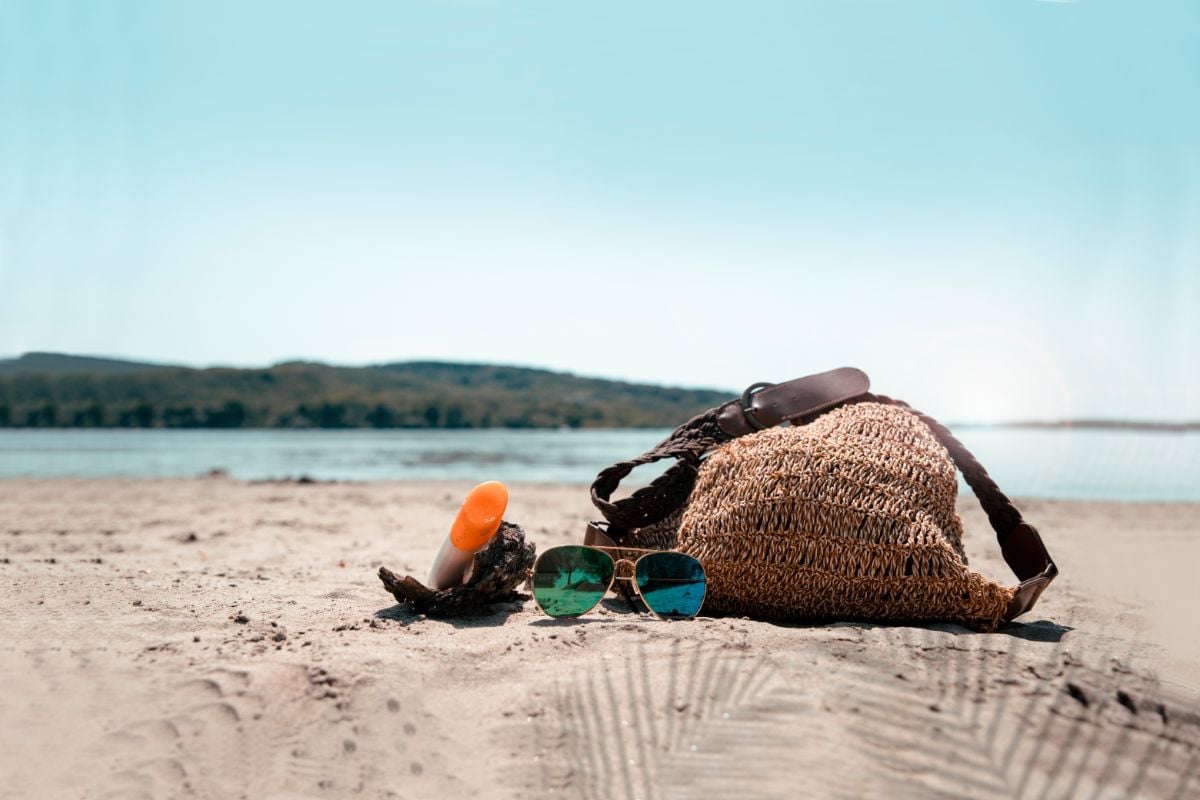 Beach bag sitting on a sandy lake shore 