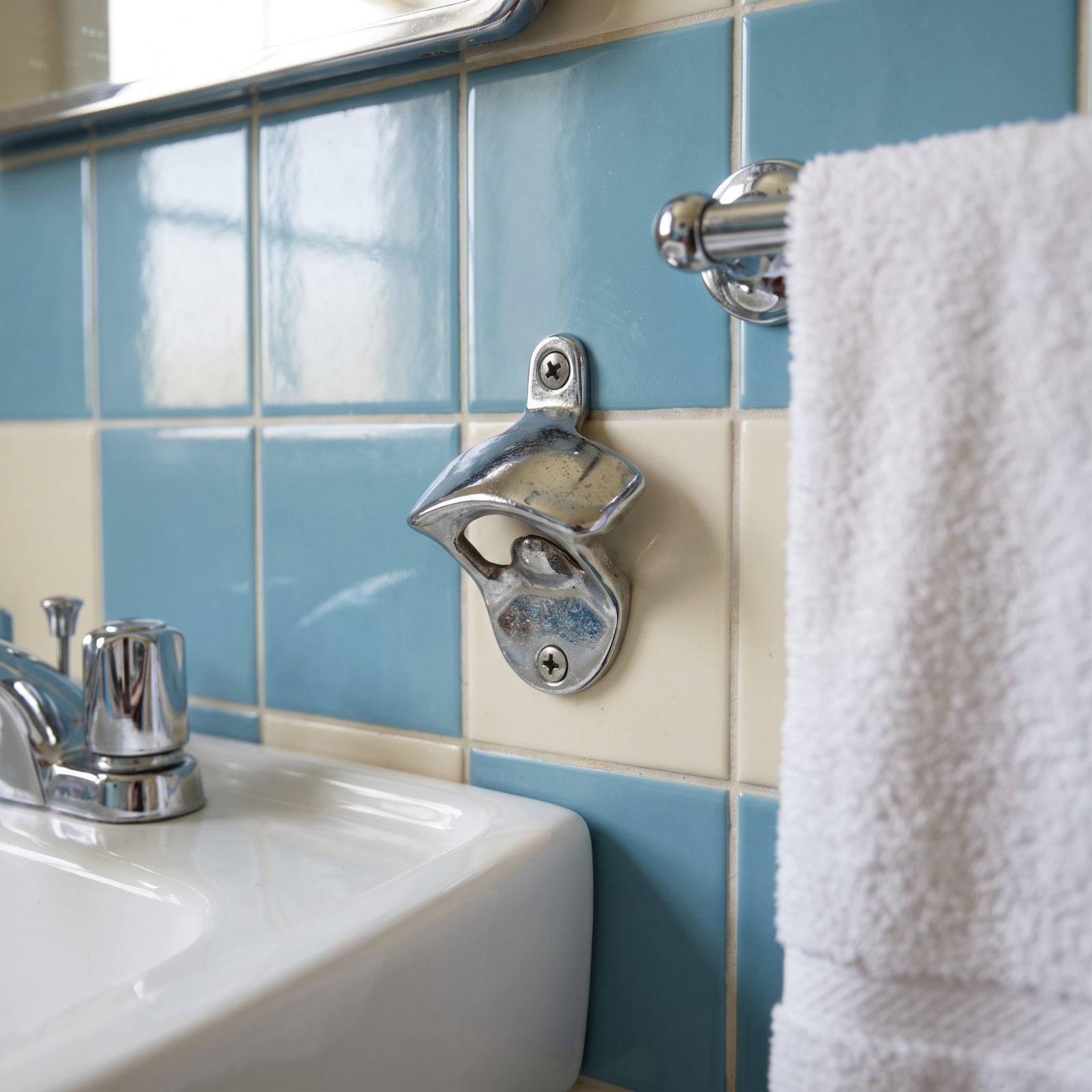 The Metal Bottle Opener Screwed Into the Bathroom Wall