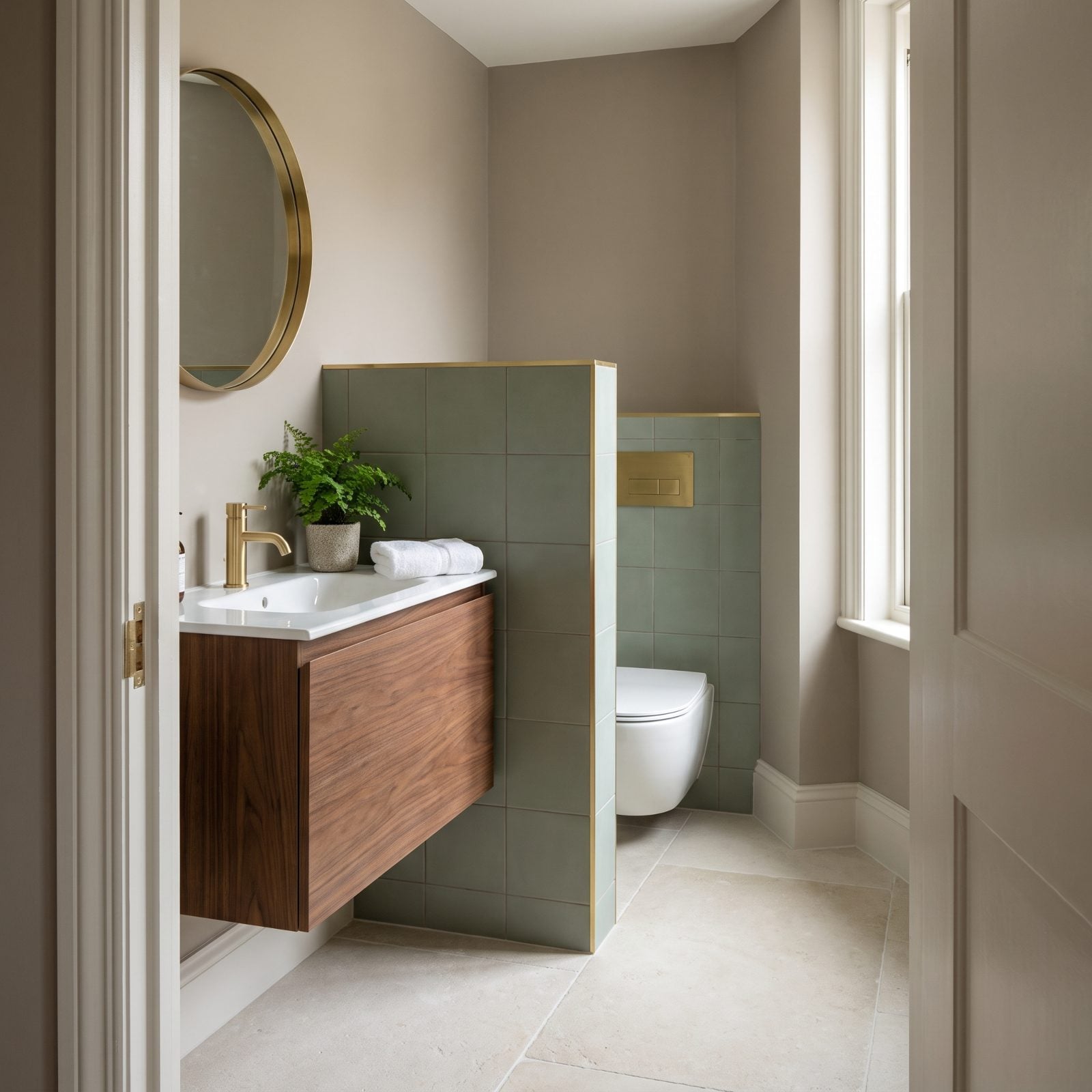 A Toilet Tucked Behind a Vanity Gains Privacy Without a Full Wall